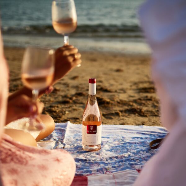 Butelka hiszpańskiego wina Tamaral Rosado na piaszczystej plaży