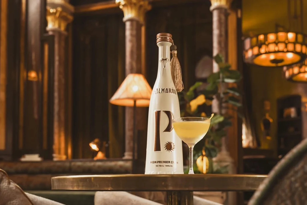 Drink z ginem PALMARÁE ustawiony obok butelki w luksusowym wnętrzu.