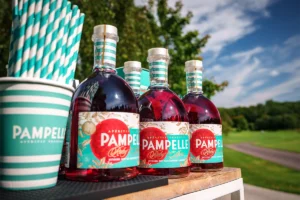 Co to jest aperitif? Butelki Pampelle Ruby Red Grapefruit Aperitif na zewnętrznym barze, gotowe do serwowania na evencie.