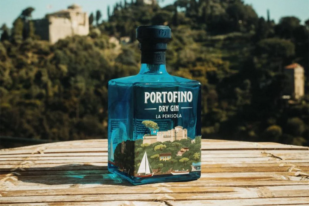 A bottle of Portofino La Penisola gin against a picturesque Italian landscape.