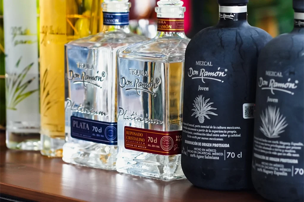 Ekskluzywna tequila Don Ramón Platinium oraz butelki Mezcal Joven na półce barowej.