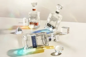 Trzy butelki luksusowej Tequili Don Ramón Platinium: Plata, Reposado Cristalino i Añejo Cristalino, otoczone szklanymi kryształami rozpraszającymi światło.